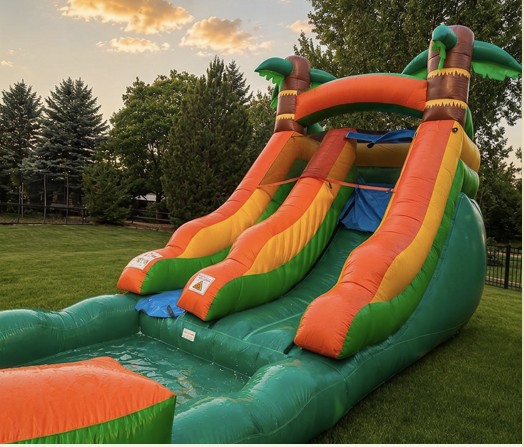 Inflatable water slide with a large splash pool landing in a backyard at golden hour